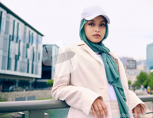 Image of Portrait, city fashion or religion with an islamic woman outdoor in a cap and scarf for contemporary style. Arabic, faith or hijab with a trendy young muslim person posing outside in urban clothes