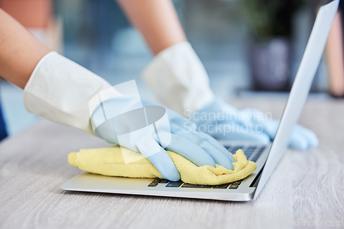 Image of Hands, cleaning laptop keyboard with cloth, wipe away dust and bacteria with disinfectant with hygiene and closeup. Person with gloves clean pc, technology and office maintenance with cleaner service