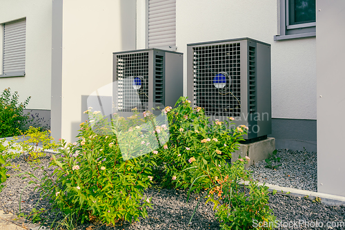 Image of Modern air source heat pumps installed outside of new and modern city house