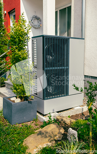 Image of Modern air source heat pump installed outside of new city house