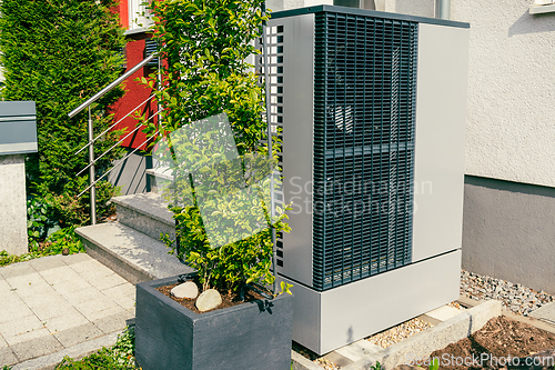 Image of Modern air source heat pump installed outside of new city house