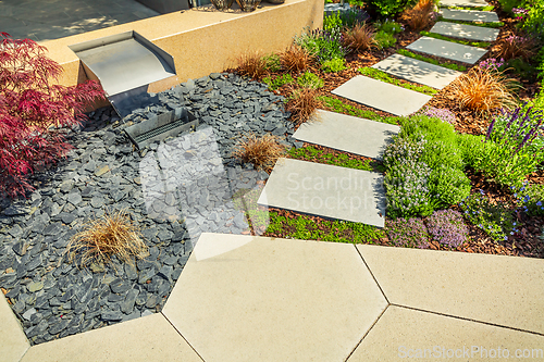 Image of Detail of  garden path with stone slabs with bark mulch and native plants. Landscaping and gardening concept.