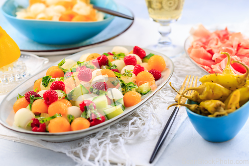 Image of Summer light food. Cucumber and melon salad  with raspberries an