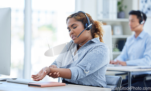 Image of Call center, wrist pain and woman in office suffering carpal tunnel while working in customer service. Hand, injury and lady consultant with arthritis, osteoporosis or muscle weakness in crm or faq
