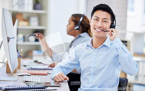 Image of Portrait, call center and Asian man smile for customer service, telemarketing or tech support. Face, crm and sales agent, consultant or employee coworking at help desk, business office and consulting