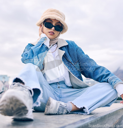 Image of Portrait, fashion or eyewear with an islamic woman outdoor in a cap and scarf for contemporary style. Muslim, faith or hijab with a trendy young arab female person posing outside in modern sunglasses