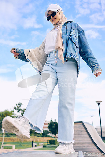 Image of Balance, fashion or religion with a muslim woman outdoor in a cap and scarf for contemporary style. Islam, faith and hijab with a trendy young arab female person standing on one leg in modern clothes