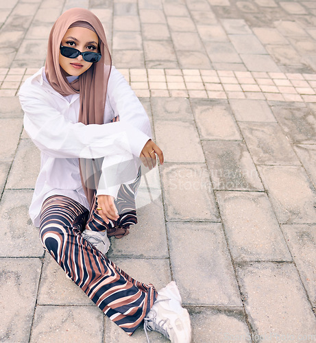 Image of Portrait, fashion or city with a muslim woman outdoor in sunglasses and a scarf for urban style. Islam, religion or arabic and a trendy young saudi person sitting outside in modern clothes with space