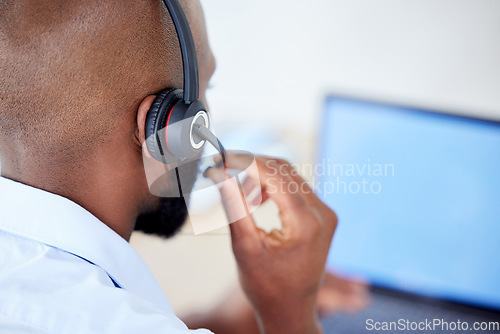 Image of Consultant, back view of black man with headset and laptop at his desk for support. Telemarketing or customer service, online communication or networking and African male call center agent at work