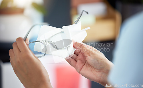 Image of Hands, vision and a person cleaning glasses in her office with a tissue for clear eyesight closeup. Wiping, prescription lenses and frame with an adult holding eyewear to clean using a wet wipe