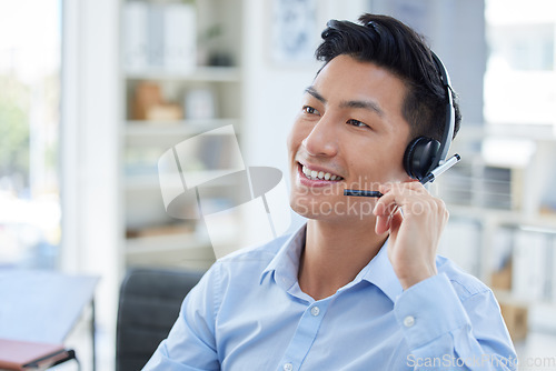 Image of Smile, call center and asian man in office for customer support, advice and friendly service. Happy, telemarketing and male consultant online for help, support or crm, faq or contact us communication