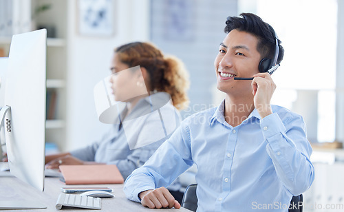 Image of Call center, smile and asian man in office for customer support, advice and friendly service. happy, telemarketing and male consultant online for help, support or crm, faq or contact us communication