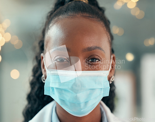 Image of Doctor, face mask and african woman, hospital and safety from bacteria, germs and night for healthcare. Black female medic, nurse and dark clinic with headshot, vision and portrait with ppe at job