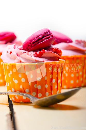 Image of pink berry cream cupcake with macaroon on top