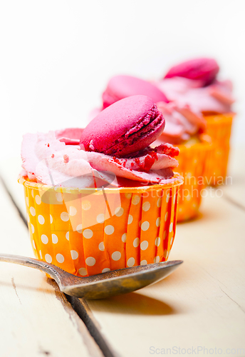 Image of pink berry cream cupcake with macaroon on top