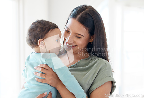 Image of Smile, mother and holding baby in home for love, care and quality time together for childcare, development and growth. Mom carrying infant kid, newborn girl and support of comfort, bond and happiness