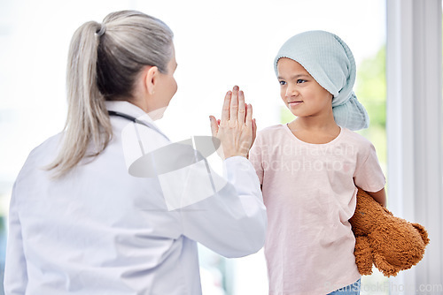 Image of Cancer, high five and doctor with kid support, healthcare service and success or empathy, courage and healing in hospital. Girl or sick kid and pediatrician or medical woman helping or hands together