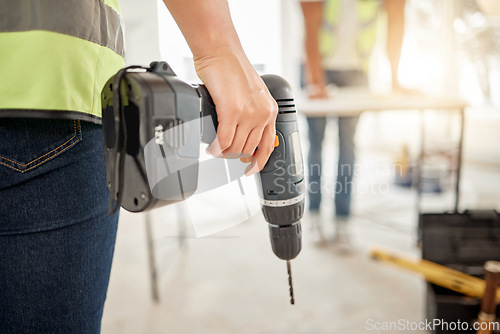 Image of Drill, construction and hand of handyman for home renovation, maintenance or carpenter work. Back of engineer, constructor or contractor person with electric power tools in room or building site