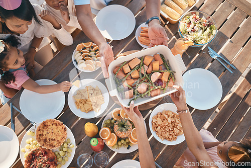 Image of Aerial, food and family at outdoor table for birthday, celebration and party, eating together. Top view, social event and parents with children at picnic with meal, lunch and bonding to celebrate