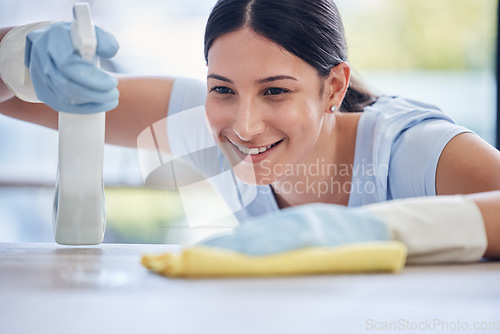 Image of Happy woman, housekeeper and detergent for cleaning table, hygiene or bacteria and germ removal at home. Female person, cleaner or maid spraying or wiping furniture or surface for dust, dirt or stain