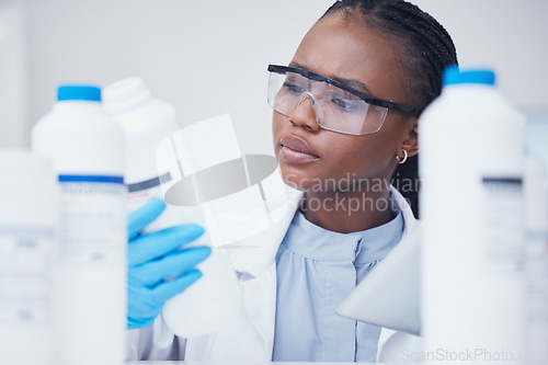 Image of Label check tablet, chemical bottle and black woman scientist with mask at pharmaceutical lab. Research, digital reading and science of a female worker with manufacturing job and chemistry inventory