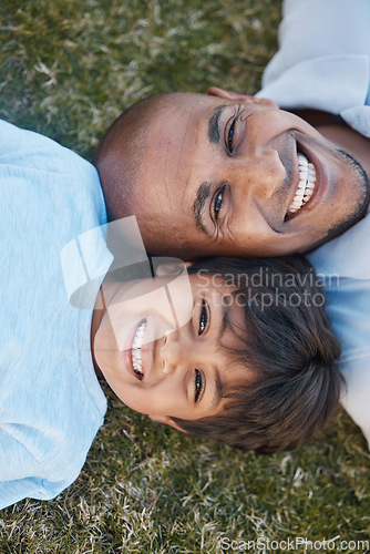 Image of Family, portrait and lying on grass in backyard with father and kid together with love. Face, top view and dad with child on holiday with with parent support and care on a lawn with happy smile