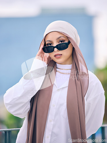 Image of Portrait, fashion or sunglasses with a muslim woman in dubai wearing a cap and scarf for contemporary style. Islamic, faith and hijab with a trendy young arab person posing outside in modern eyewear