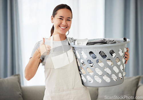 Image of Happy asian woman, laundry and thumbs up for housekeeping, cleaning or hygiene at home. Portrait of female person, cleaner or domestic with smile and thumb emoji, yes sign or like for clean clothing