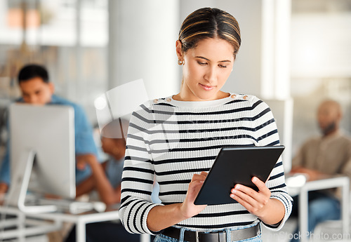 Image of Serious, tablet and business woman, designer or creative in coworking office. Touchscreen, technology and female professional typing on email app, design research or website, internet and reading.