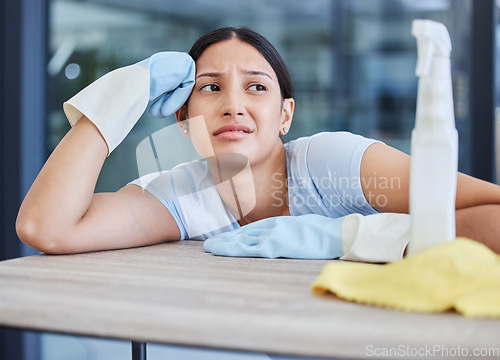 Image of Maid, detergent product and woman tired from cleaning furniture, counter and table in apartment living room. Housework, exhausted and frustrated worker with spray bottle to clean with products