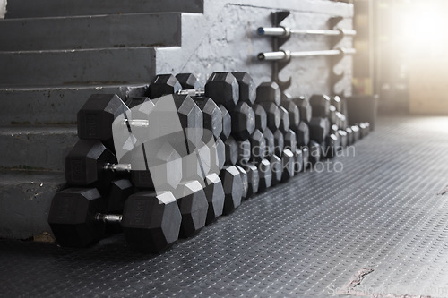 Image of Equipment, gym weights and floor of room or empty facility for fitness, sports and exercise club mockup. Dumbbells, barbell stack and weight rack in a dark training gymnasium for workout class