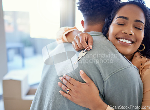 Image of Happy couple, hug and real estate with key for moving in new home or mortgage loan together indoors. Woman hugging man with smile in happiness, property or investment with keys to apartment building