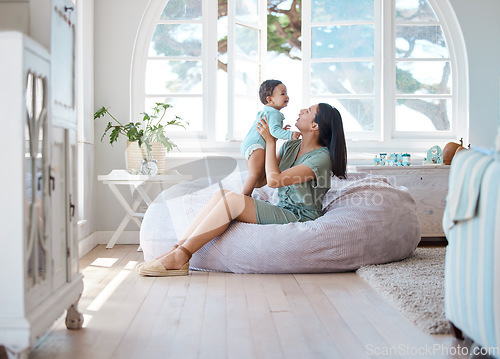 Image of Home, mother and holding baby to relax on bean bag for love, care and quality time together in childhood development. Mom, infant and carrying newborn kid in living room for support, fun and comfort