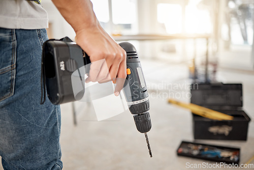 Image of Drill, handyman and hand of a man at construction site for maintenance or carpenter work. Back of male engineer, constructor or contractor worker with electric power tools in building for renovation