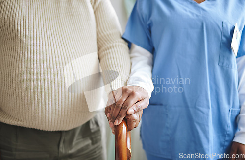 Image of Nurse, holding hands and senior patient with a cane for support, healthcare and kindness at nursing home. Person, caregiver and woman together for trust, elderly care and help in retirement