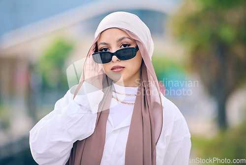 Image of Portrait, fashion or sunglasses with an arabic woman outdoor in a cap and scarf for contemporary style. Islam, faith and hijab with a trendy young muslim person posing outside in modern eyewear