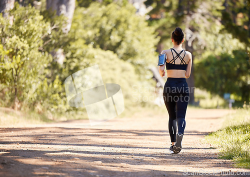 Image of Woman, fitness and running in nature for exercise, cardio workout or training in the outdoors. Rear view of fit, active and sports female person, athlete or runner exercising for healthy wellness