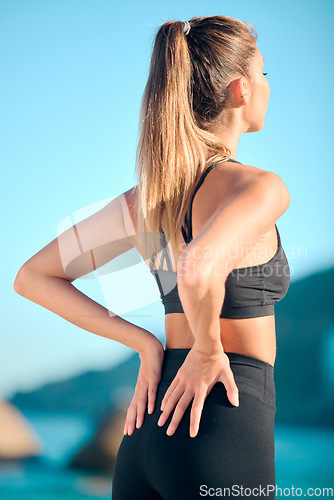 Image of Woman, beach yoga and stretching back for fitness, wellness and exercise with peace, nature or freedom. Girl, pilates and workout by ocean for mindfulness, muscle or chakra balance in summer sunshine