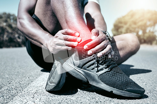 Image of Fitness, ankle and pain with a sports man holding a joint injury while outdoor for a workout. Exercise, anatomy emergency or accident with a male athlete feeling tender while training for recreation