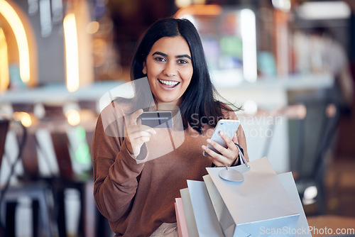 Image of Portrait, bags and woman with credit card, smartphone and shopping with boutique clothes, retail and shopping. Face, female person and customer in a store, smile and cellphone with payment and sales