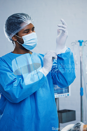 Image of Doctor in surgery, man in healthcare and surgical procedure start with PPE for safety in operation theatre in hospital. Medical professional, health insurance and male surgeon in protection gear