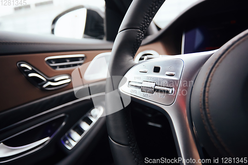 Image of Control buttons on steering wheel. Car interior.