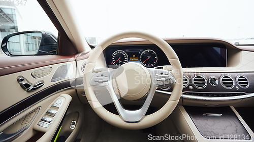 Image of Car interior luxury. Interior of prestige modern car. Leather comfortable seats, dashboard and steering wheel. White cockpit with exclusive wood and metal decoration