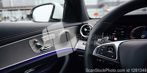 Image of Control buttons on steering wheel. Car interior.