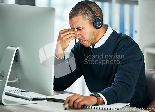 Image of Stress, call center and a man with a headset at computer for customer service problem. African person consultant at pc with headache for telemarketing mistake, crm support and help desk or sales fail