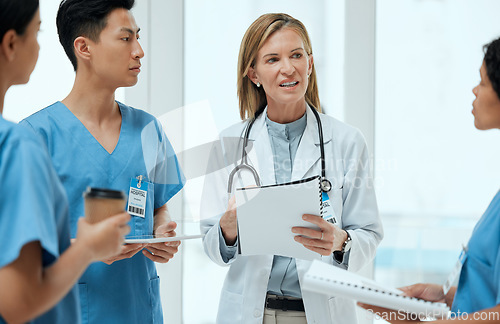 Image of Teamwork, discussion or doctors with a report in meeting planning a surgery strategy in collaboration. Leadership, woman or surgeons talking or speaking of healthcare paperwork, documents or research