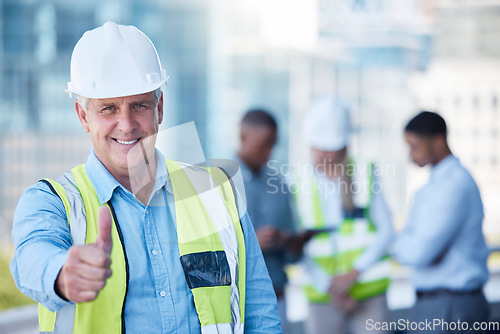 Image of Portrait, thumbs up and a senior man construction worker outdoor on a building site with his team in the background. Management, motivation and support with a mature male architect saying thank you