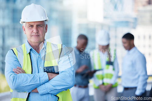 Image of Portrait, arms crossed and a serious man construction worker outdoor on a building site with his team in the background. Management, leadership and confidence with a senior architect standing outside