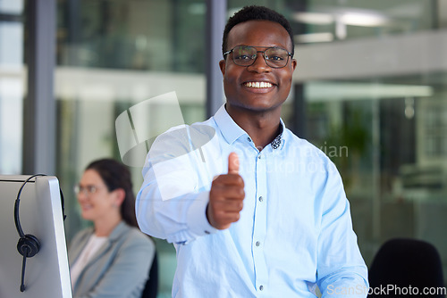 Image of Portrait, thumbs up and a black man at work in a call center for support, motivation or assistance. Customer service, thank you and success with a male consultant working as a winner in telemarketing