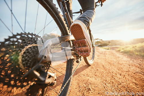 Image of Summer, cycling and a man on a bike and dirt road for fitness, morning cardio or adventure in nature. Sports, feet and a person on a bicycle for a race, competition or exercise in the countryside